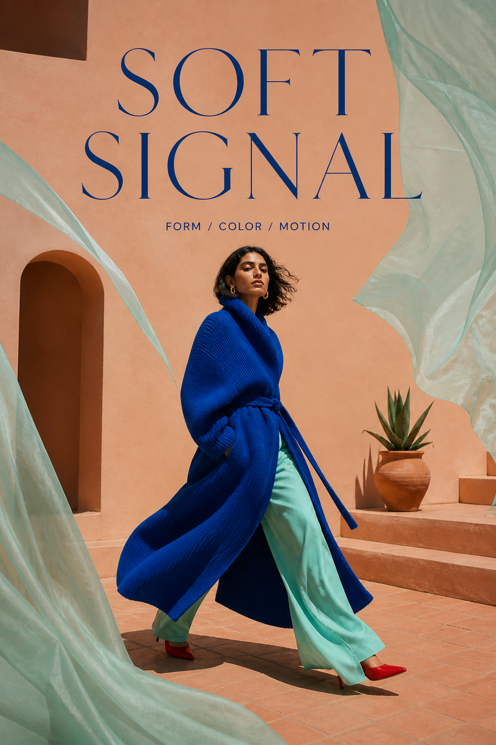 Woman in a cobalt knit coat walking through a terracotta courtyard